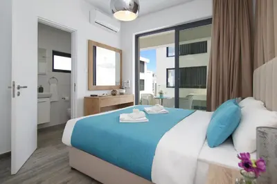 a bedroom with a blue and white bed and a bathroom at Villa Talia in Protaras