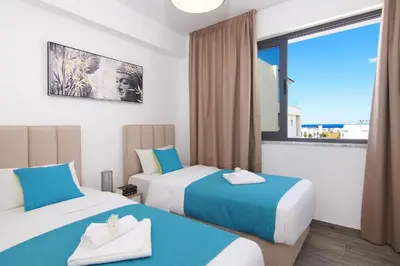 a hotel room with two beds and a window at Villa Talia in Protaras