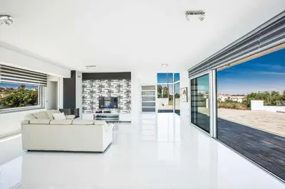 a living room with white furniture and large windows at Villa Pallas KO1 in Protaras