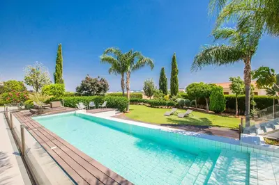 a swimming pool in a villa with palm trees at Villa Nyx in Protaras