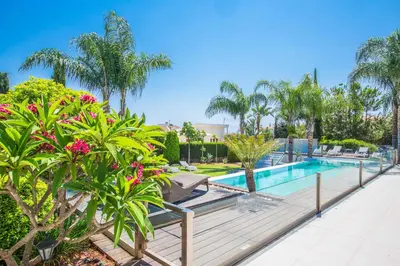 a swimming pool with palm trees and a resort at Villa Nyx in Protaras