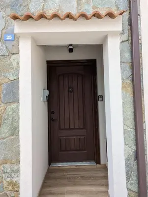 a brown door in a stone building with a wooden floor at Archontiko Adamou in Kyperounda