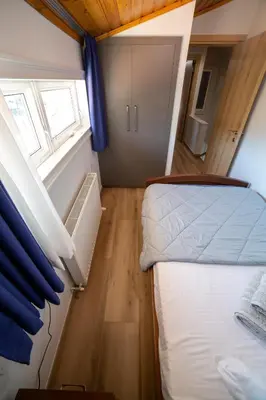 a small bedroom with two beds and a window at Archontiko Adamou in Kyperounda