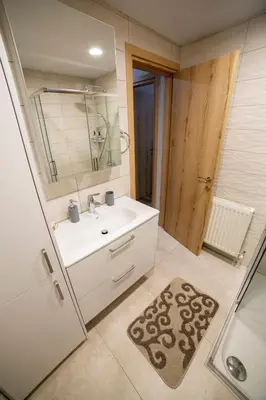 a bathroom with a sink and a shower and a mirror at Archontiko Adamou in Kyperounda