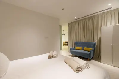 a bedroom with a bed and a blue chair at Vivo Mare Beachfront Villas - Emerald in Ayia Napa