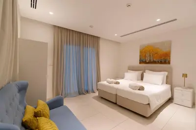 a bedroom with a bed and a blue couch at Vivo Mare Beachfront Villas - Emerald in Ayia Napa