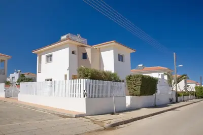 a white house with a white fence at Velomar Villa in Paralimni