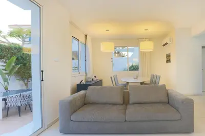 a living room with a couch and a table at Pernera Gardens Villa in Protaras