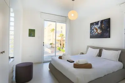 a white bedroom with a large white bed and a window at Pernera Gardens Villa in Protaras