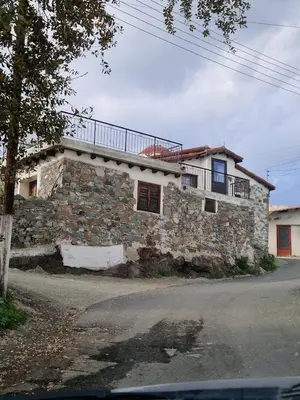 a stone house with a balcony on top of it at THE ROCK HOUSE - Beautiful countryside with mandarins oranges and olive trees,. Near Limassol at Eptagonia village. in Ephtagonia