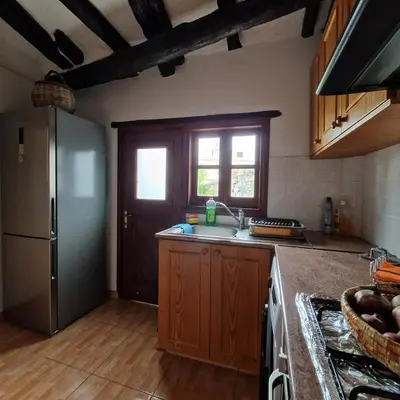 a kitchen with a refrigerator and a counter top at THE ROCK HOUSE - Beautiful countryside with mandarins oranges and olive trees,. Near Limassol at Eptagonia village. in Ephtagonia