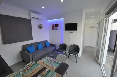 a living room with a couch and a table and chairs at Tsolias Apartments in Protaras