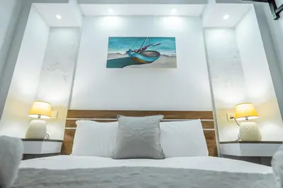 a bedroom with a bed with two lamps at Tsolias Apartments in Protaras