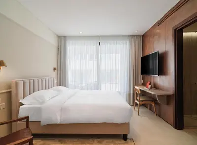 a bedroom with a bed and a desk and a television at LIV Mackenzie Beach Suites Larnaca ADULTS ONLY in Larnaka