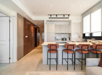 a kitchen with a island with bar stools at LIV Mackenzie Beach Suites Larnaca ADULTS ONLY in Larnaka