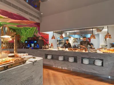 a restaurant kitchen with two people preparing food at NYX Hotel Limassol in Limassol