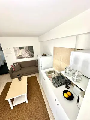 a small kitchen with a stove and a couch at Harbour Seaside Escape in Ayia Napa