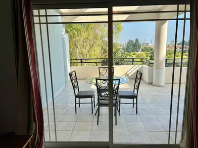 a patio with a table and chairs on a balcony at Two Bedroom City Seaside Apartment in Limassol