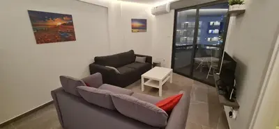 a living room with a couch and a table at Prime Beachfront Apartment on Larnaca Finikoudes in Larnaka
