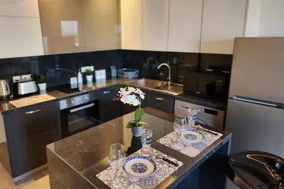 a kitchen with a counter with plates and glasses on it at Prime Beachfront Apartment on Larnaca Finikoudes in Larnaka
