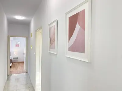 a hallway with three framed paintings on a wall at Phaedrus Living Down Town Flat Stephania 302 in Limassol