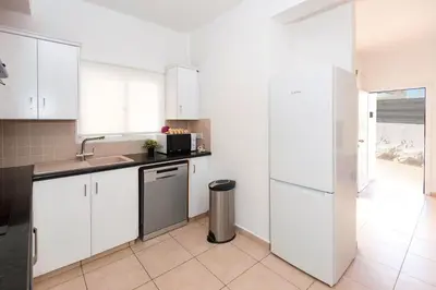 a kitchen with white cabinets and a stainless steel refrigerator at Villa White Star - 100m from Serena Beach in Protaras