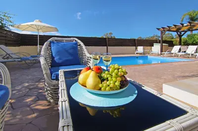 a bowl of fruit on a table next to a pool at Nissi Dreams Villa in Ayia Napa