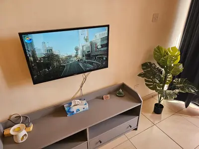 a living room with a flat screen tv on the wall at STEFARIS PROPERTIES 