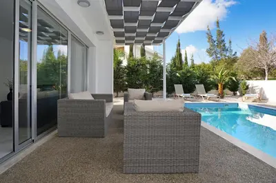 a patio with wicker chairs and a swimming pool at Villa Catalina in Ayia Napa