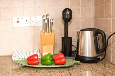 a counter with a plate of peppers and a coffee maker at Villa Mandy in Protaras