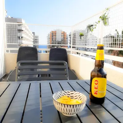 a bottle of beer and a bowl of food on a table at Sea Breeze Central, 2bed in Limassol