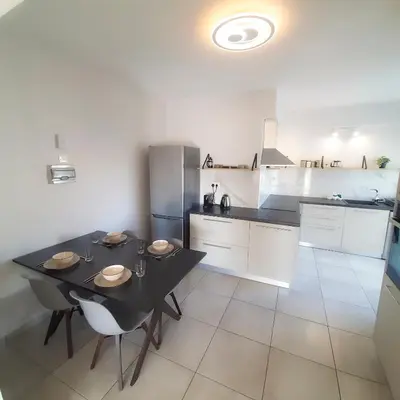 a kitchen with a table with chairs and a refrigerator at Sea Breeze Central, 2bed in Limassol