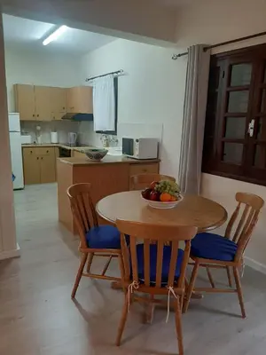 a kitchen with a table and chairs with a bowl of fruit on it at Klimataria B2 in Pissouri