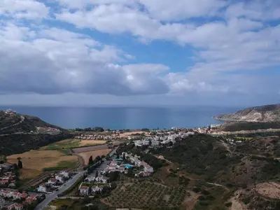 an aerial view of a town on a hill next to the ocean at Klimataria B2 in Pissouri