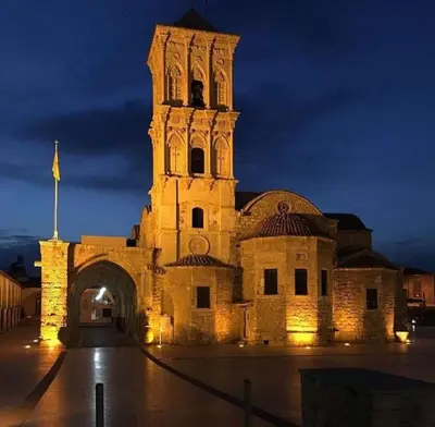 a large building with a clock tower at night at Anamor apartment 408 in Larnaka