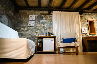 a bedroom with a bed and a chair and a mirror at Archontiko Rousias in Nicosia