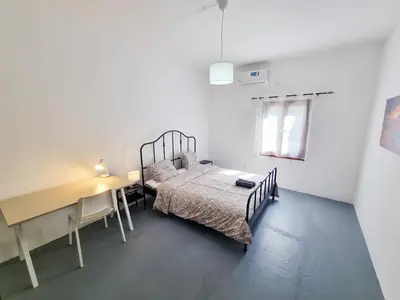 a bedroom with a bed and a desk and a bed and a table at Mountains Retreat Rooms & Suites in Ayios Theodhoros