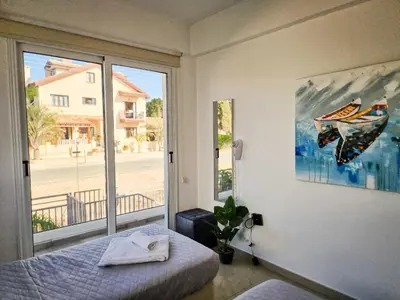 a bedroom with a bed and a large window at Nissi beach villa Magnolia in Ayia Napa