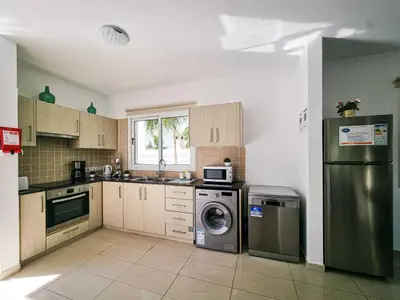 a kitchen with a stainless steel refrigerator and a washer at Nissi beach villa Magnolia in Ayia Napa