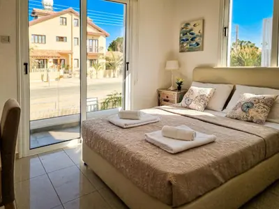a bedroom with a large bed with two towels on it at Nissi beach villa Magnolia in Ayia Napa