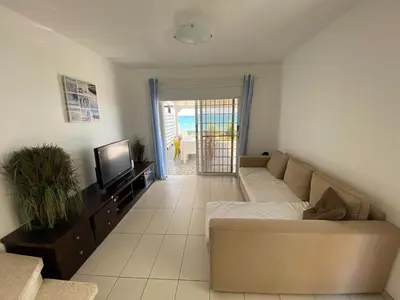 a living room with a couch and a television at Seafront Beach House in Meneou