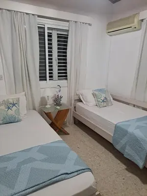 a bedroom with two beds and a window at Seafront Beach House in Meneou