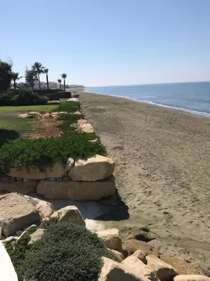 a beach with some rocks and the ocean at Beach Front Periyiali Gardens in Pervolia