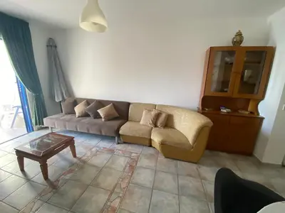 a living room with a couch and a table at Beach Front Periyiali Gardens in Pervolia