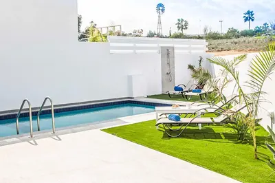 a swimming pool with two lounge chairs next to a house at Villa Macan in Protaras