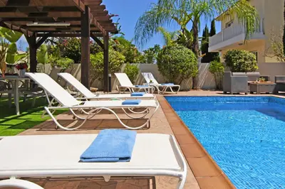 a pool with chaise lounge chairs and a swimming pool at Nissi Adamite Villa in Ayia Napa