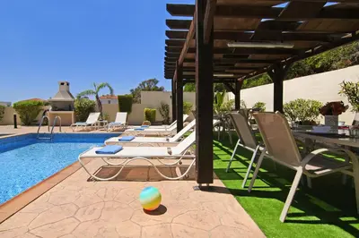a pool with lounge chairs and a ball on the ground at Nissi Adamite Villa in Ayia Napa