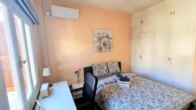 a bedroom with a bed and a couch and a window at The Urban Oasis - Comfort 2br near the City Center, 200Mbit Internet and Smart TV in Larnaka