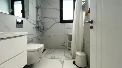 a white bathroom with a toilet and a sink at By the Bay Villa,3 BR/pool in Protaras