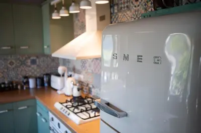a kitchen with a refrigerator with a person on it at Rozana House in Silikou